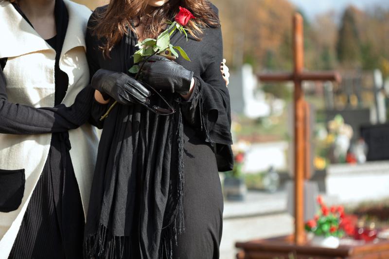 kobieta z różą ubrana na czarno na pogrzebie